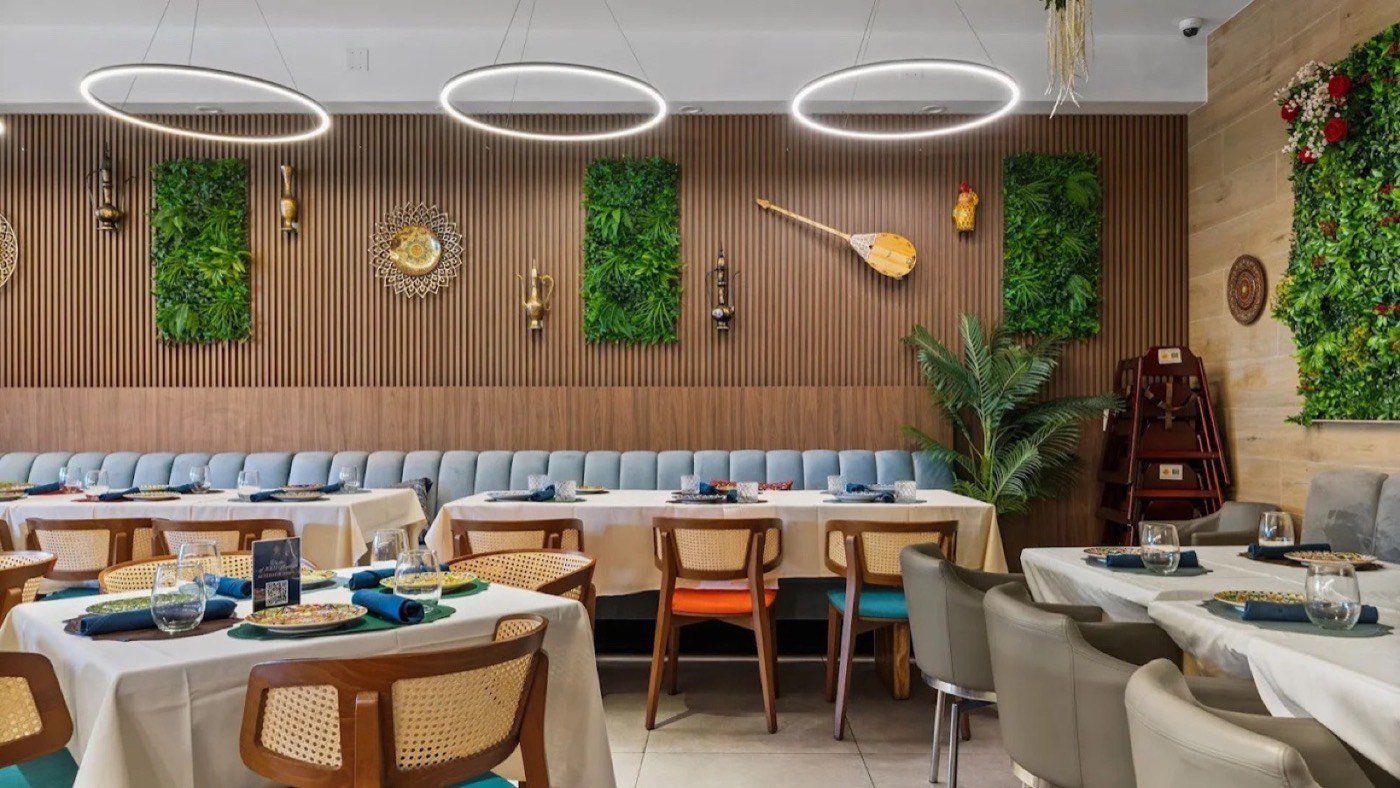 Dining room at Grandma's Secret Sunny Isles with wood-slat walls and banquette seating